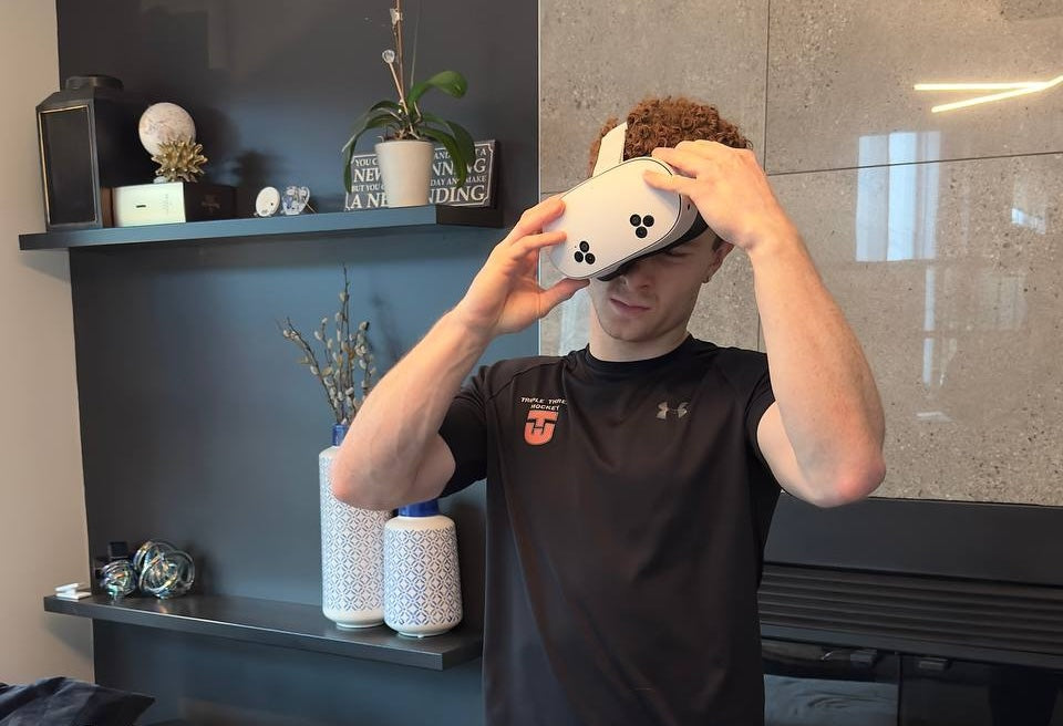 Person putting on a Meta Quest 3 headset at home